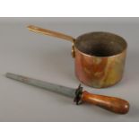 A Victorian brass and copper pan along with a wooden handled knife sharpener marked carborundum.