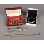 A small jewellery box containing assorted costume pieces such as necklaces and earrings. Also a