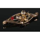 A 9ct gold ruby floral brooch. 1.45g