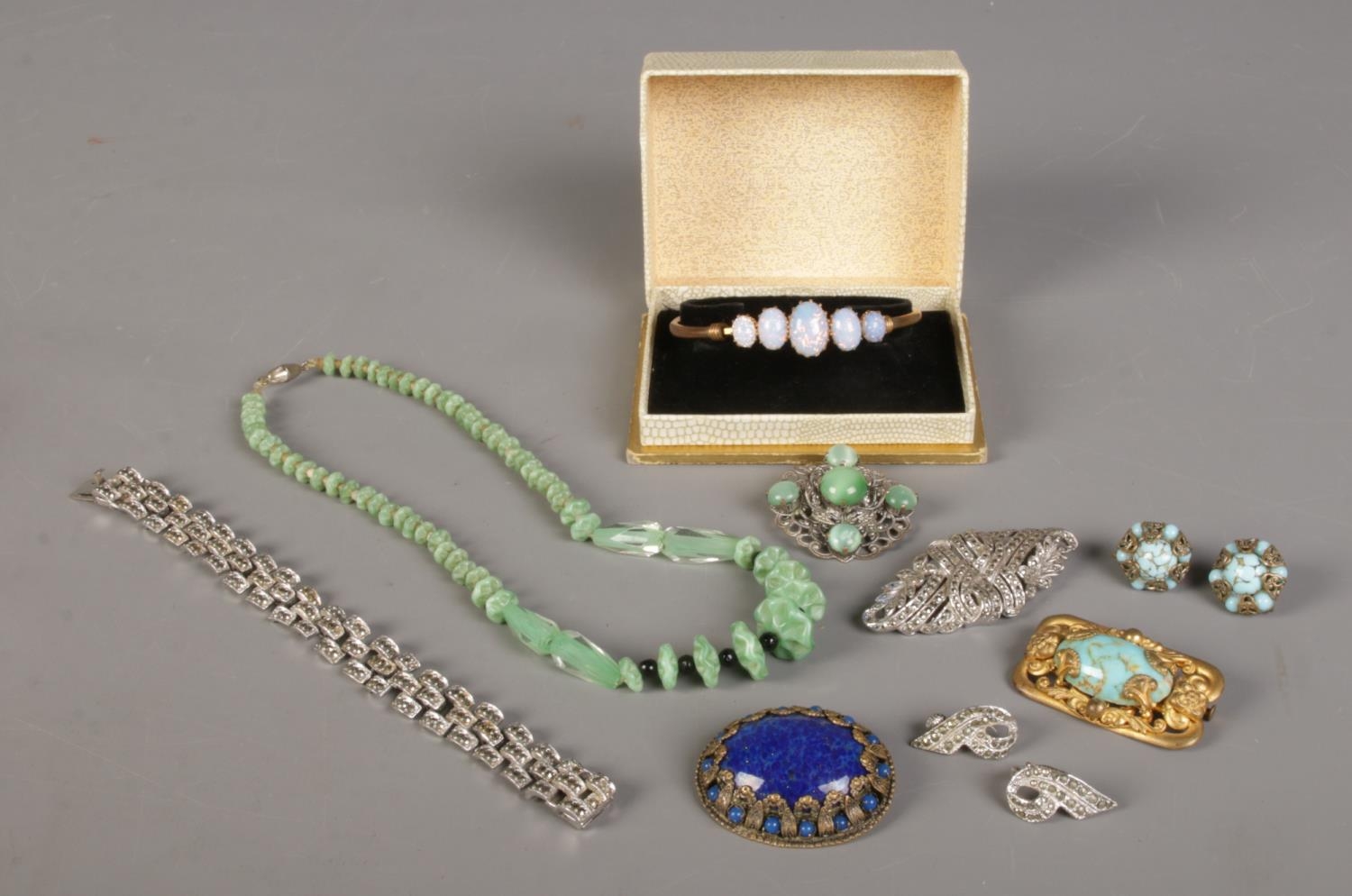 A quantity of costume jewellery, to include boxed bangle marcasite set examples, brooches and