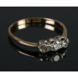 An 18ct gold and platinum diamond three stone ring. Size O. 1.74g.