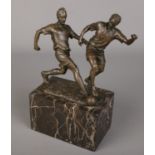 After Milo, A bronze figure group of footballers. Raised on marble plinth. (24cm)