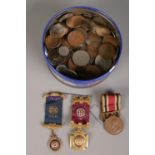 A tin of coins and medals. Including half crowns, masonic medals, pennies, foreign coin examples,
