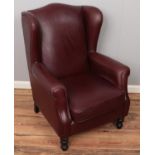 A brown leather wingback armchair. Some ware to the leather.