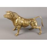 A large brass figure depicting a charging bull. Approx. dimensions 42cm x 25cm.