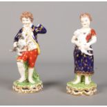 A pair of Derby figures depicting young boy and girl holding a lamb and dog. Young boy is missing