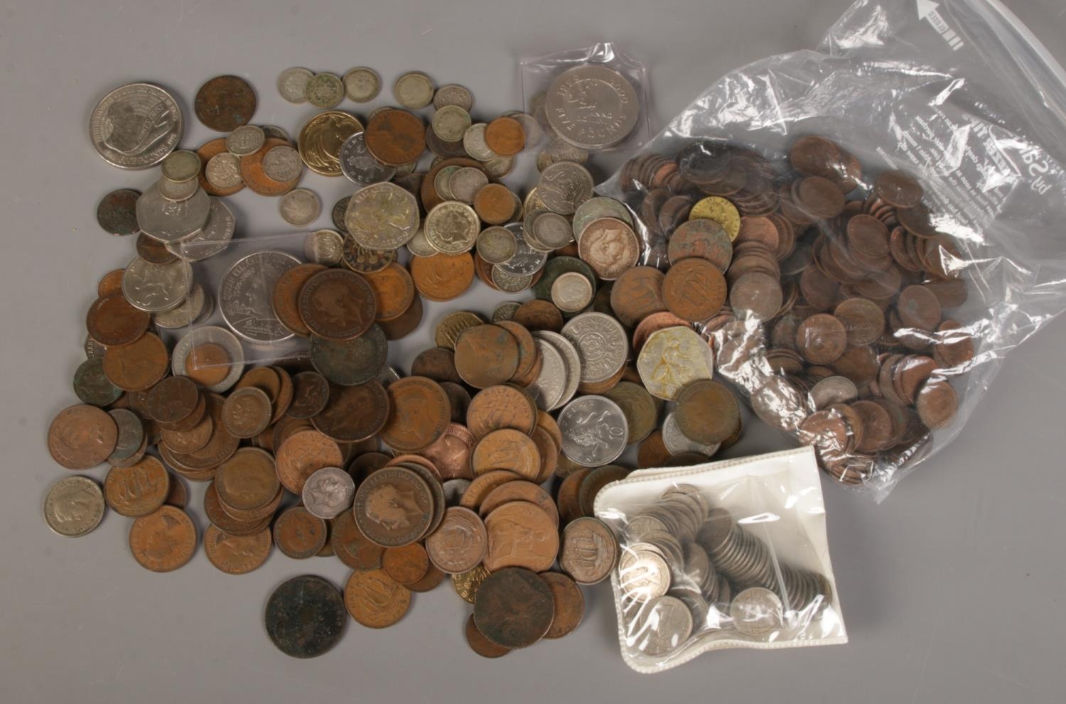 A box of British coins. Includes sixpences, threepences, five pound coins, 1788 token etc.