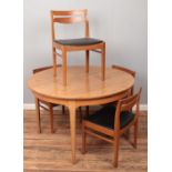 A Nathan teak extending circular dining table along with a set of four chairs.