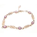 A PRETTY 375 hallmarked 9ct yellow gold scroll design bracelet with 6 oval set amethysts, lobster