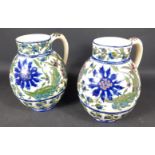 A STUNNING near pair of gilded, Zsolnay Pecs of Hungary pottery jugs with vibrant floral and