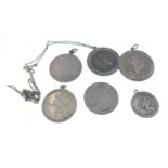 Four silver stamped St Christopher pendants (1.5 - 3cm dia) also with a silver stamped disc, a