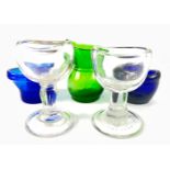 A collection of five glass EYEBATHS including two on stands