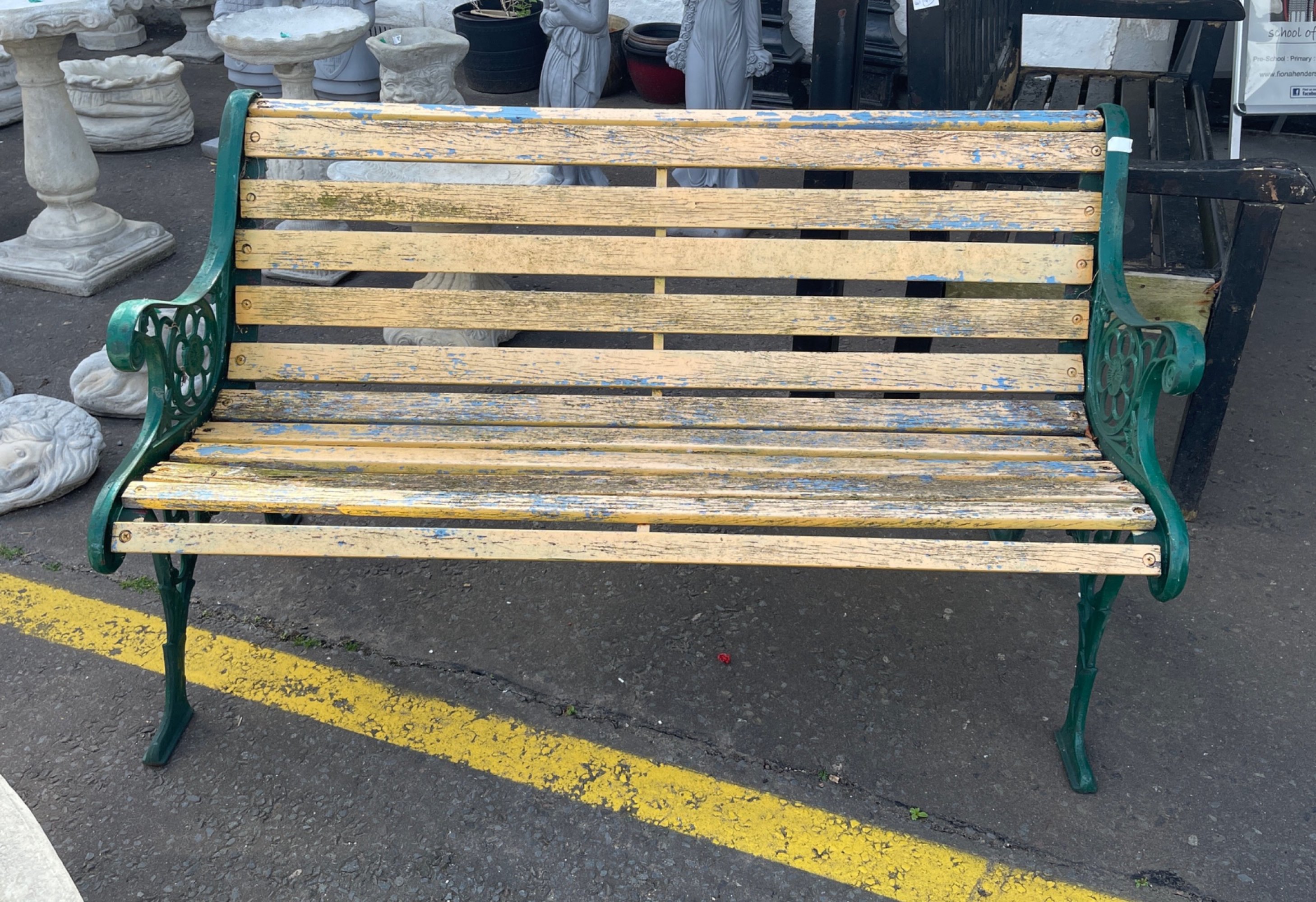 A nice wrought iron ended garden seat with distressed lemon painted wooden slats - 130cm long x