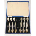 A boxed set of 12 monogrammed silver teaspoons and pair of tongs, hallmarked Sheffield 1932, by