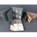 A collection of CIGARETTE CARDS contained in two albums and an old CWS Biscuit tin