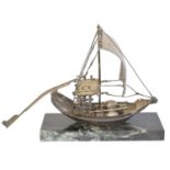 A white metal model of a Chinese Junk Boat,