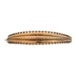 An early 20th century 9ct gold hinged bangle,