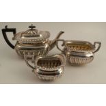 A silver three piece tea set, with fluted lower body, tea pot Birmingham 1898, milk jug and sugar