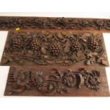 Three carved wooden panels, one carved with roses, one with grape vine and the other with