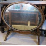 An oak framed oval swing frame toilet mirror, height 17.5ins