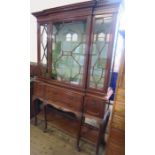 An Edwardian walnut break front display cabinet, having a glazed upper section, with two doors below