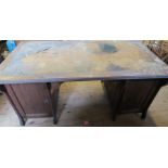 An Edwardian oak desk, having the remains of a tooled leather writing surface, fitted with cupboards