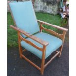 An oak Arts and Crafts style open arm chair, having three position reclining back, raised on four