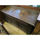 An Antique oak coffer, with three carved panels to the front, 47ins x 22ins, height 24ins