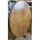 A 19th century walnut oval quarter veneered loo table, raised on a central column, with four out