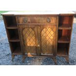 A Regency style Edwardian break front mahogany cabinet, having a central drawer, with two grilled