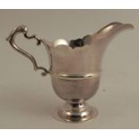 An Irish silver cream jug, with shaped edge and raised on a pedestal foot, Dublin 1969, weight 5oz