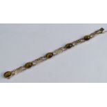 A 9 carat gold tiger eye bracelet, the five cabochons with pierced panels between, 19cm long, 16g