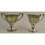 A WMF milk jug and sugar basket, having green glass liner, pierced body and raised on a beaded foot,