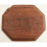 A Robert Thompson Mouseman octagonal bread board, with carved mouse, length 12ins