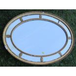 A 19th century oval wall mirror, with gilt frame and rosettes, maximum diameter 36ins