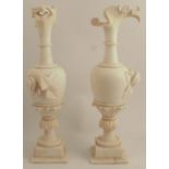 A pair of alabaster urns, the spout carved as a birds beak, with flower and leaf decoration, one