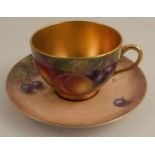 A Royal Worcester tea cup and saucer, the exterior of the cup and the saucer decorated with fruit by