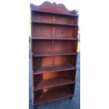 A mahogany waterfall bookcase, with a shaped cresting rail and having seven fitted shelves, raised