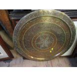 A brass circular tray, with engraved and coloured decoration, diameter 23ins