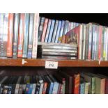 Three shelves of assorted DVDs, CDs, books, and records