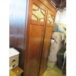 A mahogany two door wardrobe, with glass panels to the doors, having with a shelf over hanging