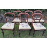 A set of six Victorian mahogany dining chairs, raised on turned front legs, with tapestry seats