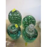 Two dump glass paperweights together with two glass bottles