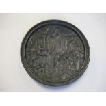 A circular metal plaque, embossed with a Classical scene, diameter 6ins
