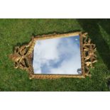 A Regency design wall mirror, with ornate scroll decoration, 22ins x 21.5ins