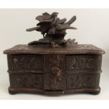 A Black Forest jewellery box, the rising lid surmounted by carved birds, opening to reveal swing out