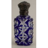 A small carved over laid blue glass scent bottle, with white metal cap, height 2.75ins