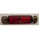 A ruby glass double ended scent bottle, with yellow metal stoppers and faceted body, length 5.25ins