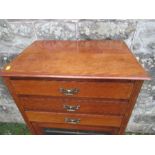 An Edwardian music cabinet, with three drop down drawers, over a glazed door, raised on tapering