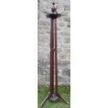 An Edwardian mahogany cloak stand, the circular ring of cloak hooks raised on three supports, with